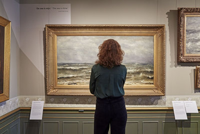 Vrouw kijkt naar een schilderij in De Mesdag Collectie